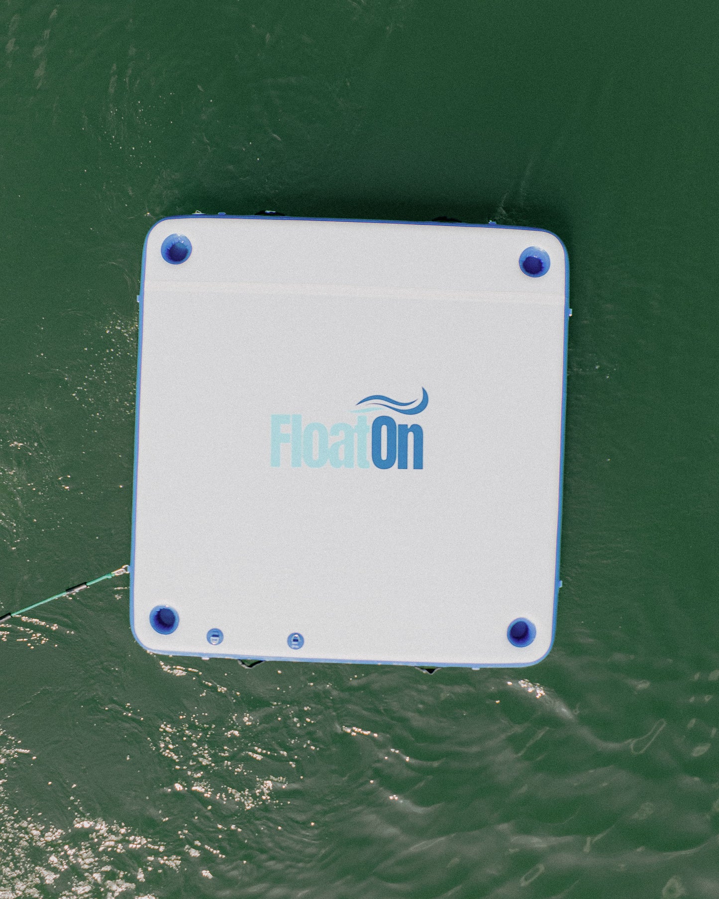 A white and blue inflatable floating dock from Float On Boat Gear.