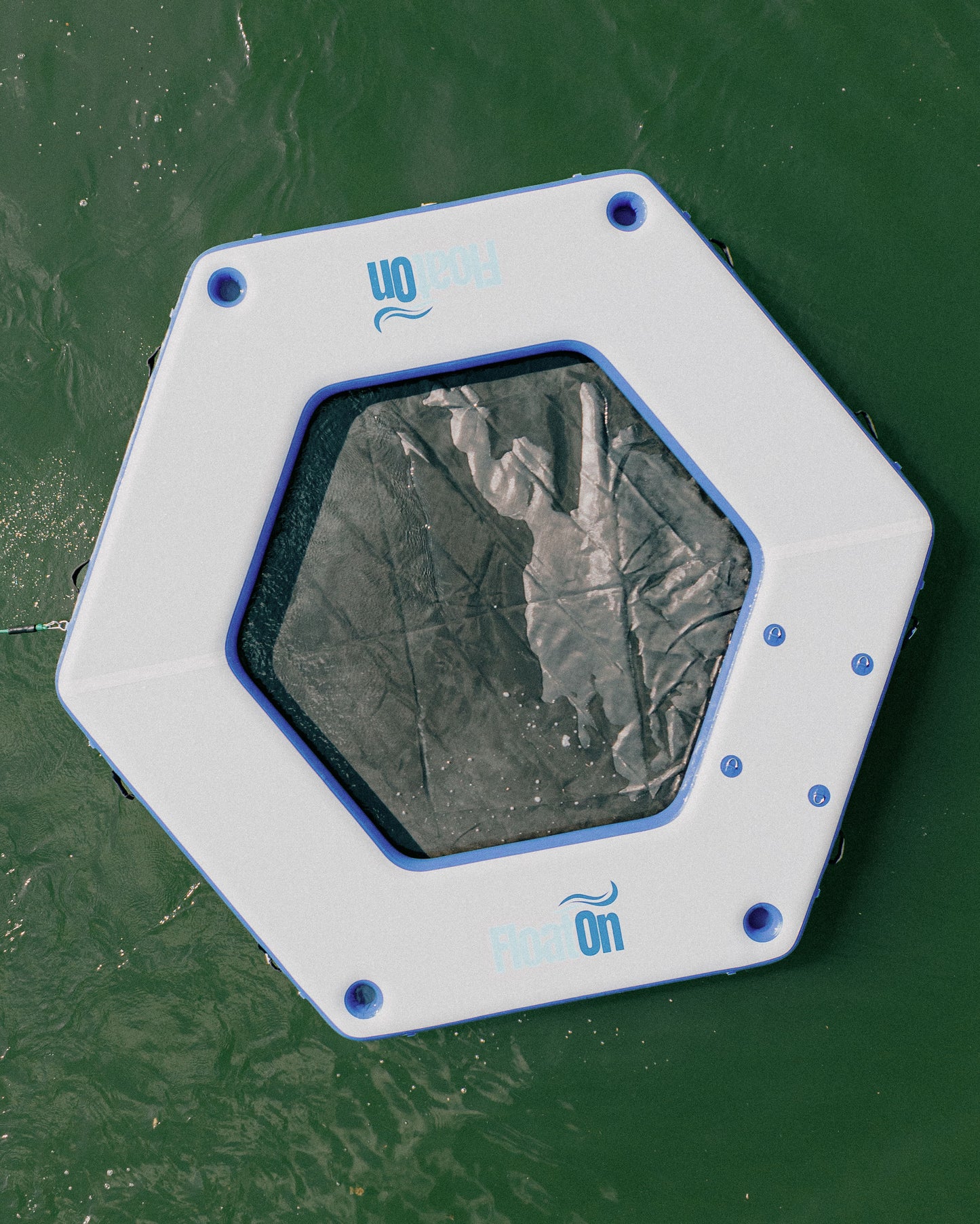 An above view of a white inflatable water mat on the lake.