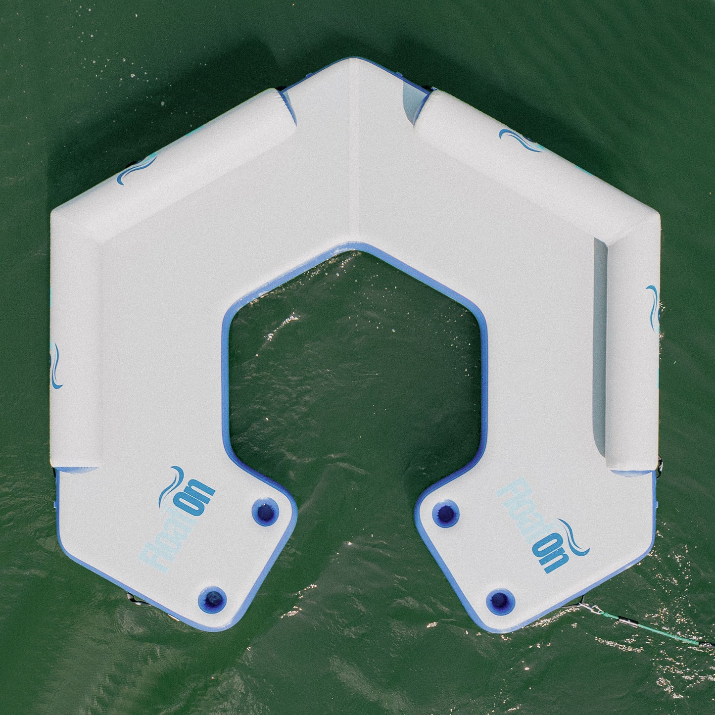 The U shaped Hangout inflatable water mat floating on the lake.